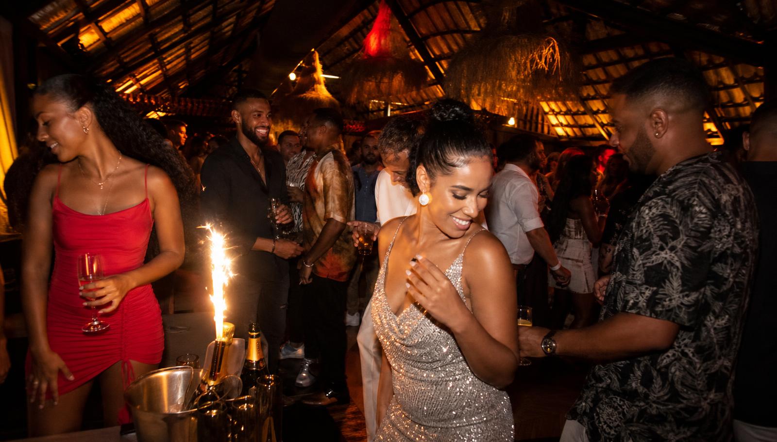 Stylish adults dressed up and dancing in a nightclub with colorful lights