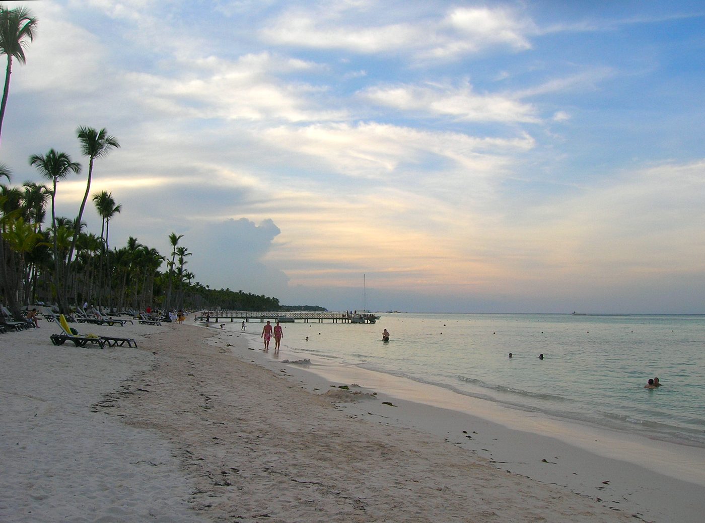 Wide white sand Caribbean beach with palm trees and calm turquoise water