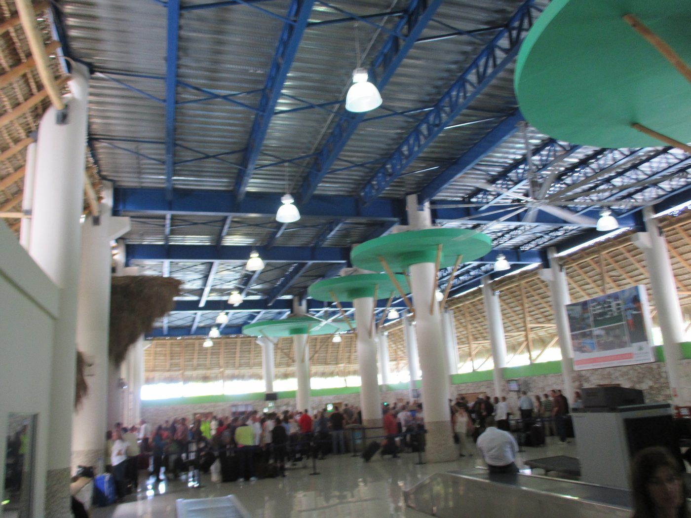 Arrivals area at Punta Cana International Airport with a driver holding a sign