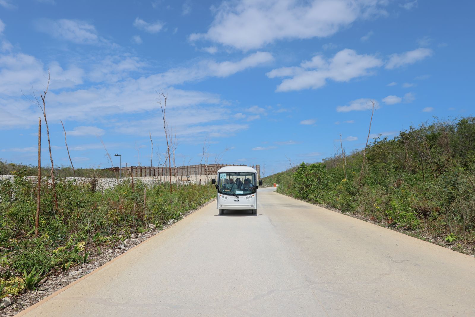 A shuttle on a sunny tropical road