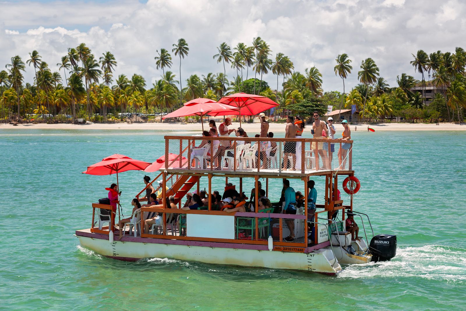 A lively Caribbean party boat full of adults dancing on deck